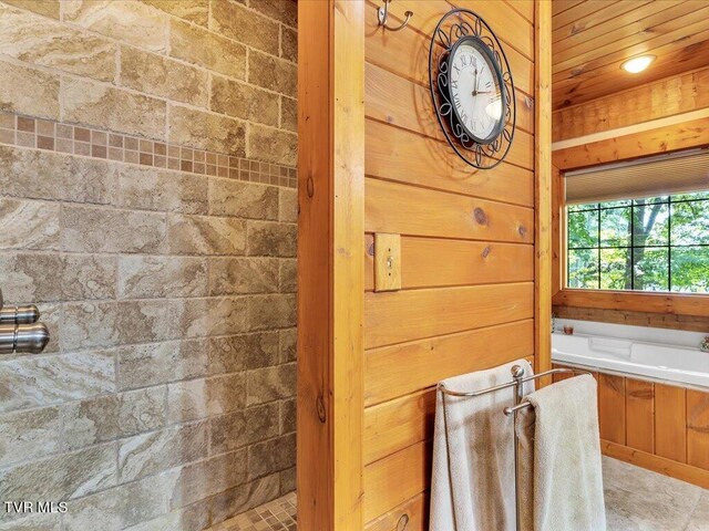 bathroom with independent shower and bath and tile patterned floors