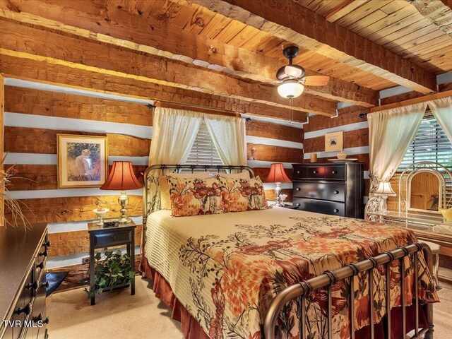 bedroom with beamed ceiling, carpet floors, wood ceiling, ceiling fan, and wooden walls