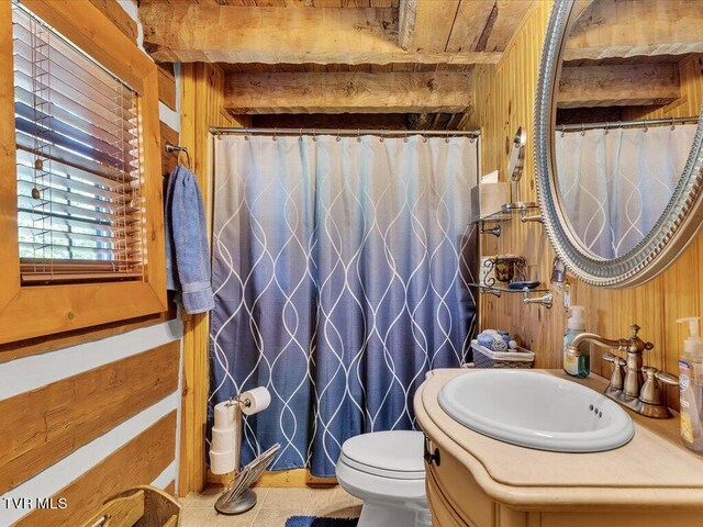 bathroom with tile patterned floors, vanity, toilet, and wooden walls