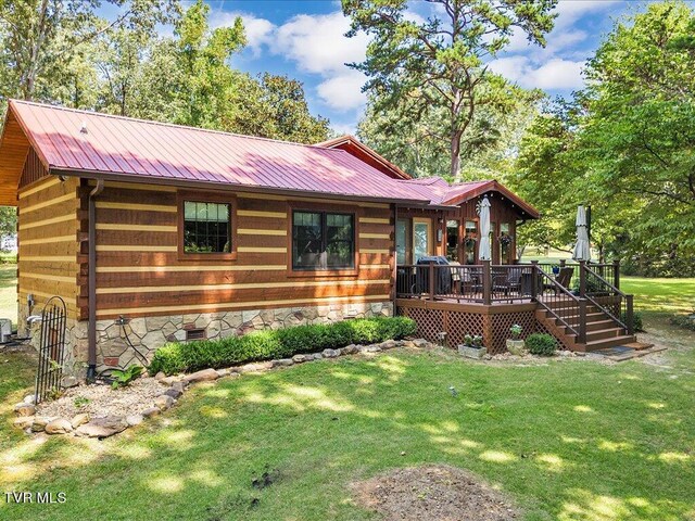 view of front of property featuring a deck and a front lawn