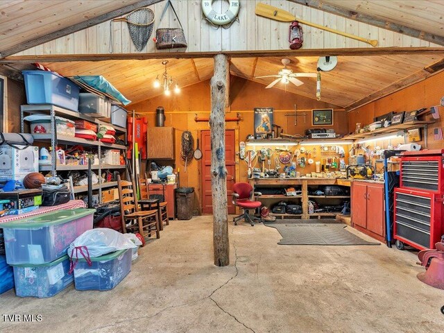 garage featuring wood ceiling, ceiling fan, wooden walls, and a workshop area