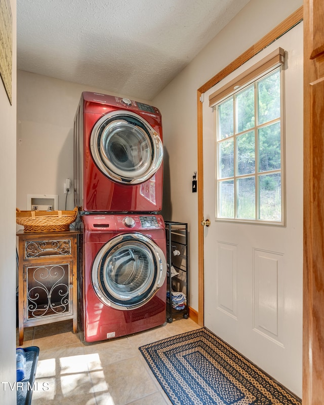 laundry room featuring a textured ceiling, stacked washer and clothes dryer, and light tile patterned flooring