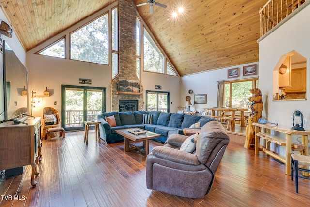 living room with plenty of natural light, ceiling fan, wood-type flooring, and high vaulted ceiling