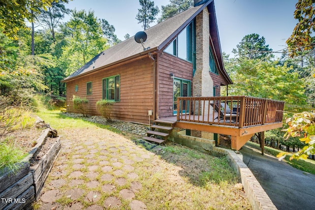 view of property exterior with a chimney and a wooden deck