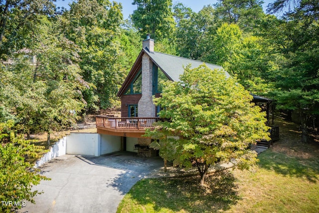 view of front of house with a chimney, driveway, and a deck