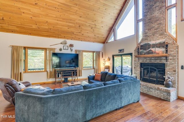 living room with baseboards, wooden ceiling, wood finished floors, a brick fireplace, and high vaulted ceiling