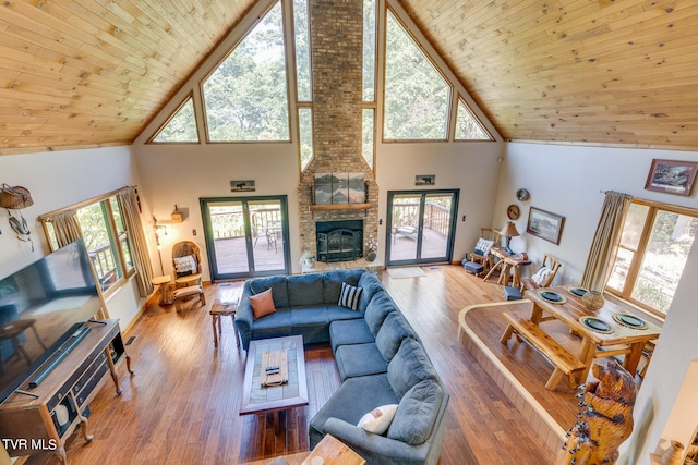 living room featuring a fireplace, hardwood / wood-style floors, high vaulted ceiling, and wooden ceiling