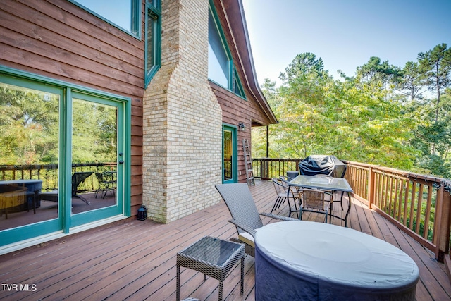 wooden deck with outdoor dining area and grilling area