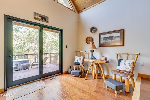 doorway to outside with wood ceiling, high vaulted ceiling, and light hardwood / wood-style flooring