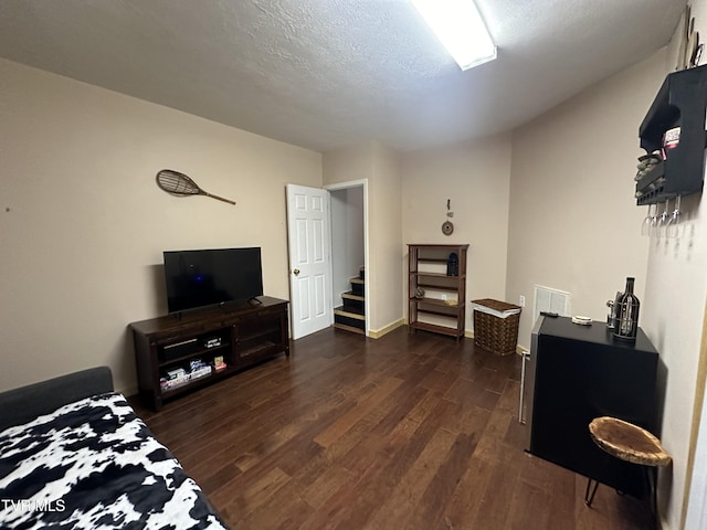 bedroom featuring dark hardwood / wood-style flooring and a textured ceiling