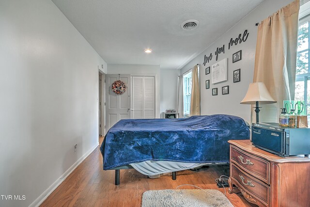 bedroom with a closet and dark hardwood / wood-style floors