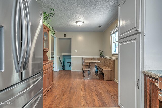 kitchen featuring stainless steel fridge, a textured ceiling, and dark wood-type flooring