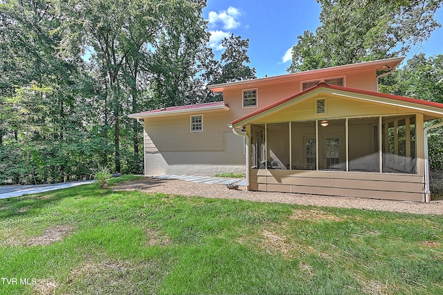 rear view of house with a sunroom and a lawn