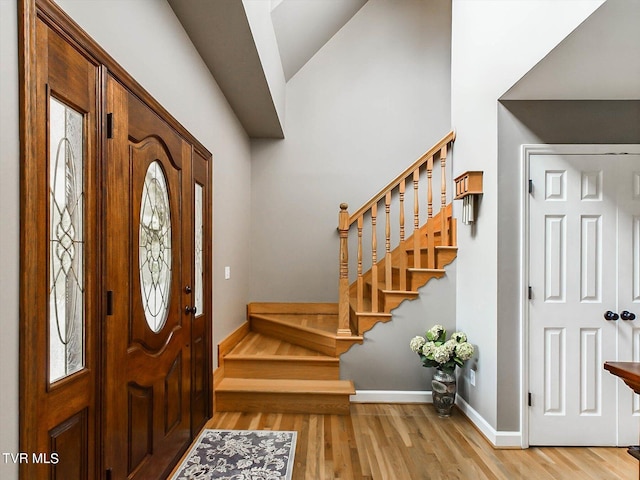 entryway with vaulted ceiling and light hardwood / wood-style floors