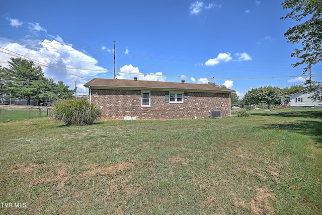 back of property featuring central AC unit and a lawn