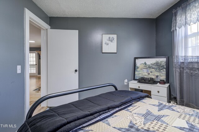 bedroom featuring wood-type flooring and a textured ceiling