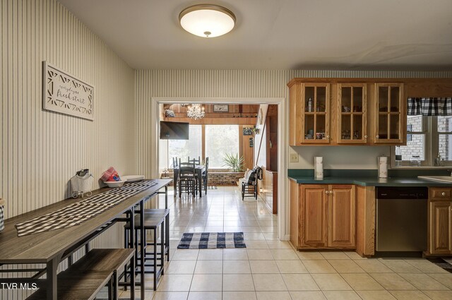 kitchen with stainless steel dishwasher, sink, and light tile patterned floors