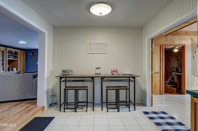 bar with wood walls and light tile patterned flooring