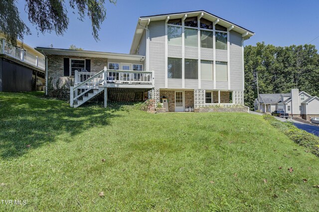 rear view of house featuring a yard and a wooden deck