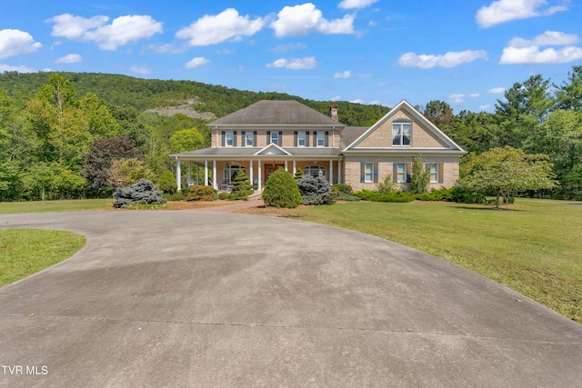 view of front of home with a porch and a front lawn