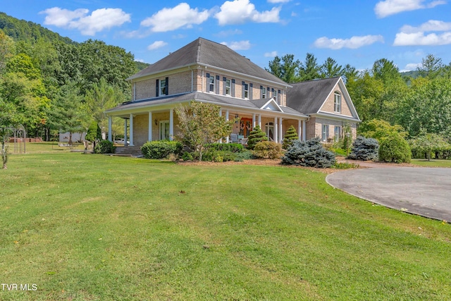 view of front of home with covered porch and a front lawn