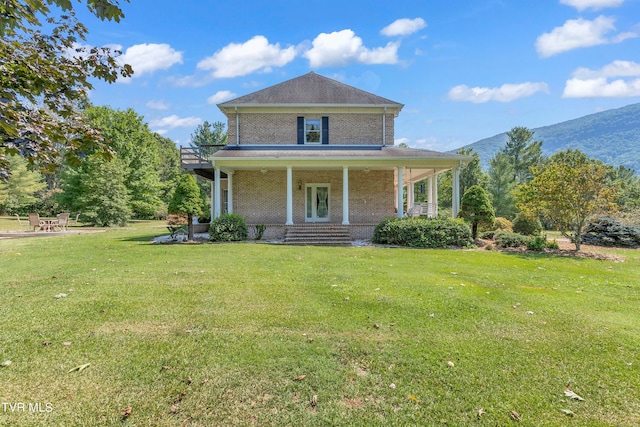 view of front facade featuring a mountain view, a front yard, and a porch