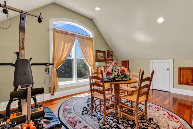 dining space with hardwood / wood-style flooring and vaulted ceiling