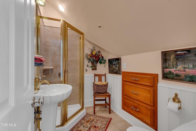 bathroom featuring lofted ceiling, toilet, an enclosed shower, and tile patterned floors