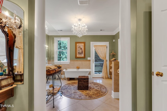 bathroom with a notable chandelier, tile patterned floors, a tub to relax in, ornamental molding, and tile walls