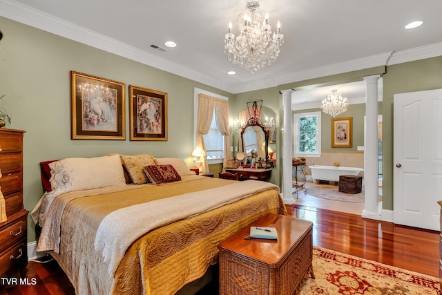 bedroom featuring hardwood / wood-style floors, decorative columns, an inviting chandelier, and crown molding