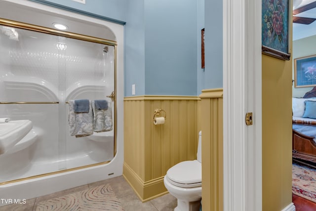 bathroom with toilet, an enclosed shower, and tile patterned floors