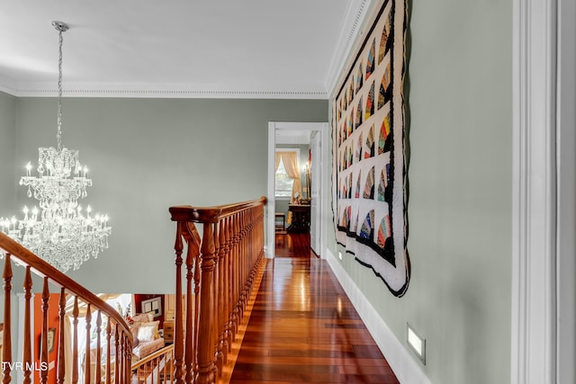 hallway featuring ornamental molding, dark wood-type flooring, and a notable chandelier