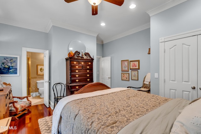 bedroom with crown molding, connected bathroom, ceiling fan, a closet, and dark hardwood / wood-style floors