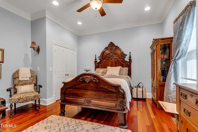 bedroom featuring crown molding, ceiling fan, a closet, and wood-type flooring