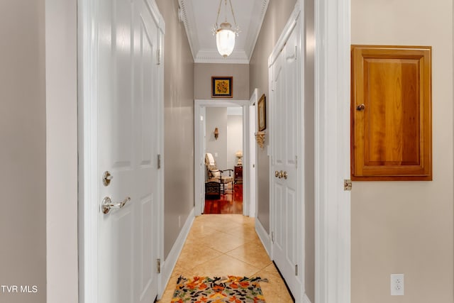 hallway featuring light tile patterned floors and crown molding