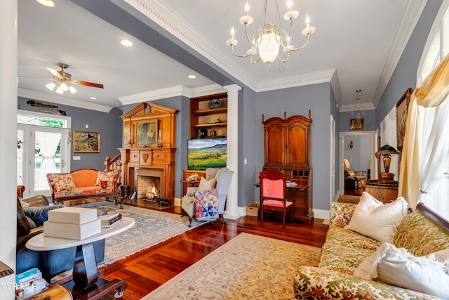 living room with ornamental molding, ceiling fan with notable chandelier, and hardwood / wood-style flooring