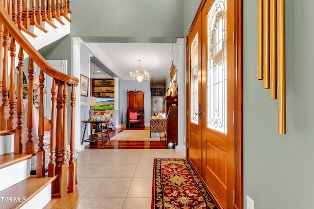 entrance foyer with ornamental molding, a chandelier, and light hardwood / wood-style floors