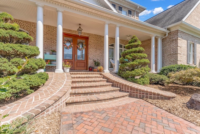 view of exterior entry featuring covered porch