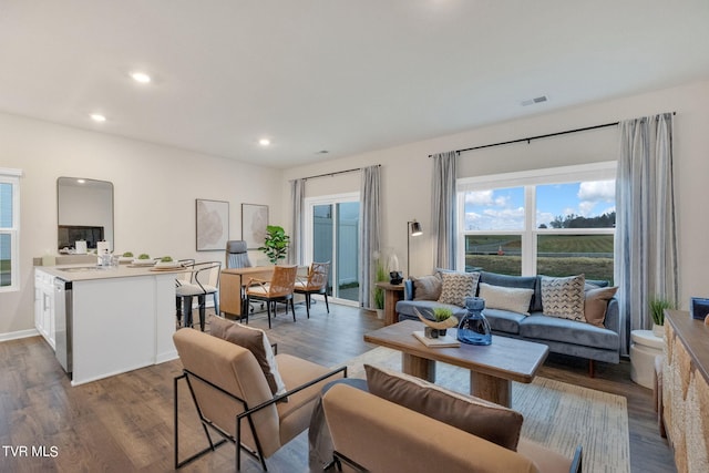 living room with visible vents, arched walkways, wood finished floors, and recessed lighting