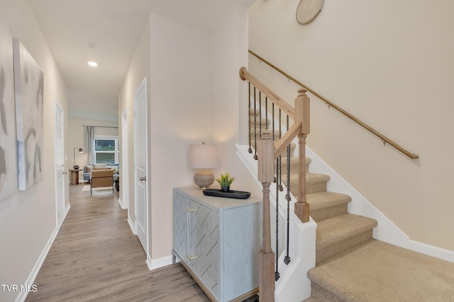 stairs with recessed lighting, wood finished floors, and baseboards