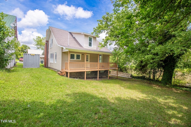 back of property with a yard and a wooden deck