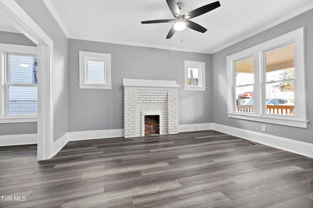 unfurnished living room with crown molding, dark wood-type flooring, ceiling fan, and a brick fireplace