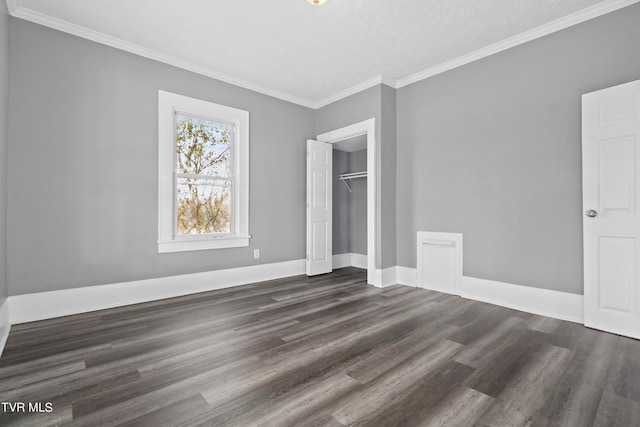 unfurnished bedroom with crown molding, dark wood-type flooring, a closet, and a textured ceiling