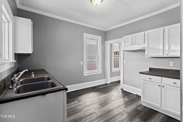 kitchen featuring crown molding, white cabinetry, sink, dark wood-type flooring, and a textured ceiling