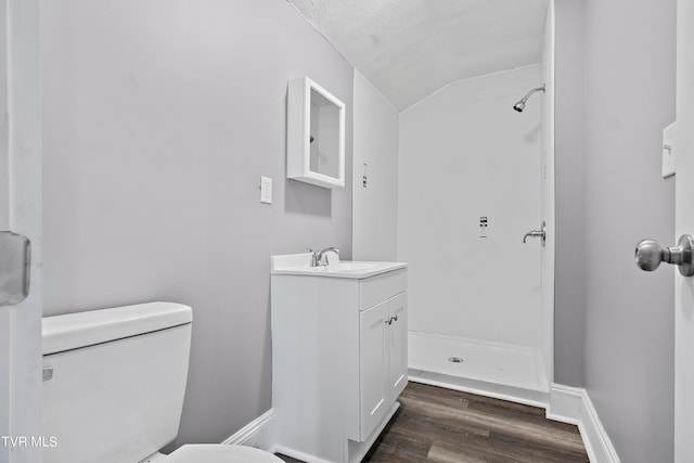 bathroom with vanity, vaulted ceiling, wood-type flooring, toilet, and a shower