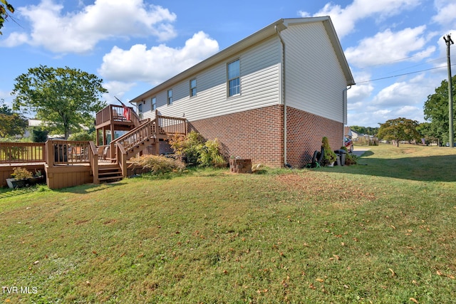 exterior space featuring a wooden deck and a lawn