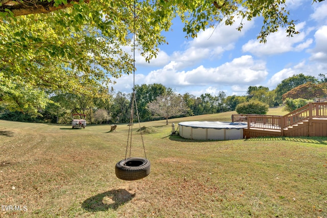 view of yard with a pool side deck and an outdoor fire pit