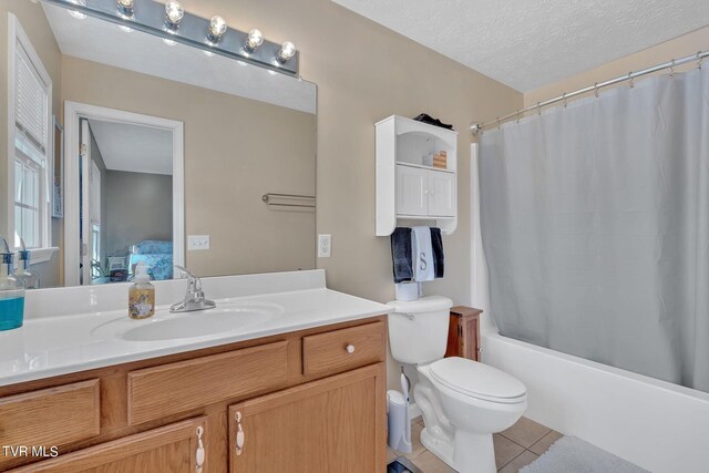 full bathroom featuring tile patterned floors, shower / bath combo, toilet, vanity, and a textured ceiling