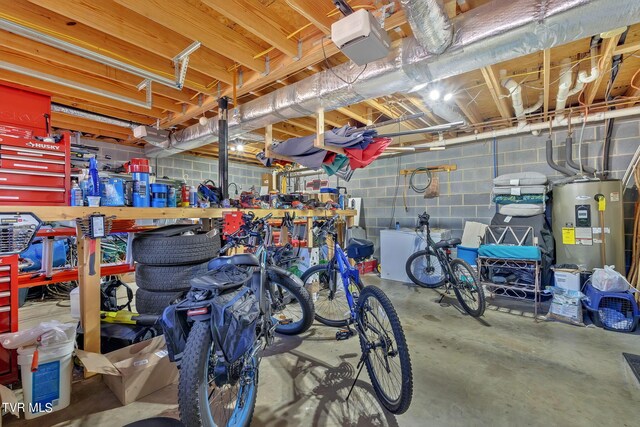 interior space featuring electric water heater, a garage door opener, and a workshop area