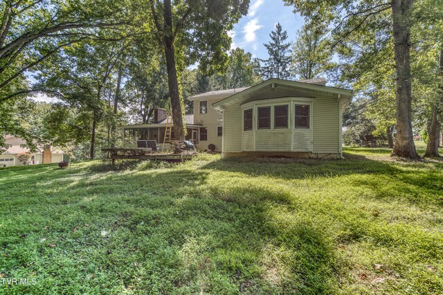 back of house with a lawn and a deck